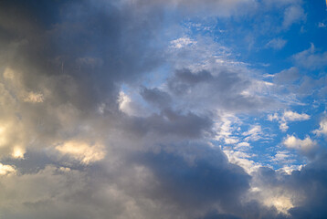 Dramatic clouds swirl and dance under a vibrant evening sky at twilight