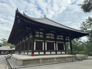 The main hall (kondo) of the Toshodai-ji Temple with its giant massive roof, stands under the deep blue sky, evoking a sense of grandeur and reverence.