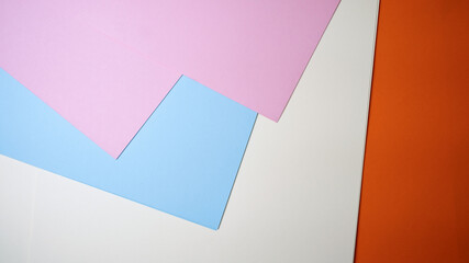 Brightly colored sheets of paper lay on a surface in vibrant hues