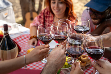 Cheers with red wine at a festive rustic outdoor gathering