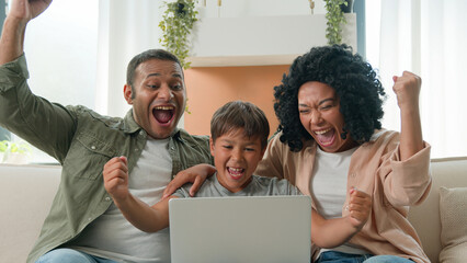 Multiracial family happy mom dad son looking at laptop together African American parents mother...