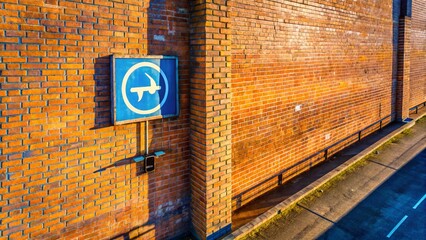 Obraz premium Aerial Drone View of Parking Sign on Brick Wall - Urban Parking Lot