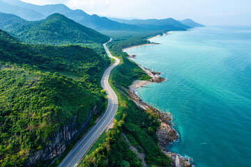 A winding coastal road surrounded by lush green mountains and turquoise sea on a sunny day.