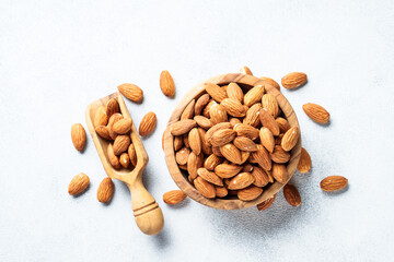 Almond nuts in wooden bowl at white background.