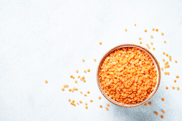 Red lentils in craft bowl on white background. Flat lay.