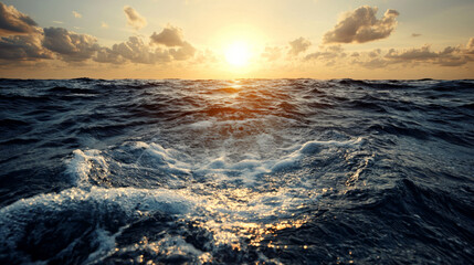 Obraz premium Sunset over the ocean with clouds reflecting golden light in the sky