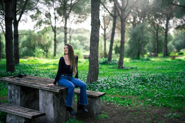 Chica joven delgada vloggeando con cámara por zona verde con arboles