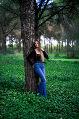 Naklejka premium Chica joven delgada vloggeando con cámara por zona verde con arboles