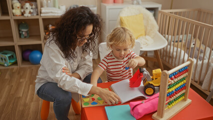 Mother and son playing together indoors in bedroom with toys and books showcases a warm family bond...