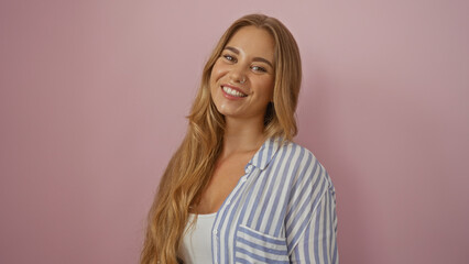 Fototapeta premium Attractive blonde woman smiling confidently over isolated pink background with her long hair cascading over her shoulders
