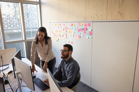 Colleagues in an office looking at a computer screen using artificial intelligence