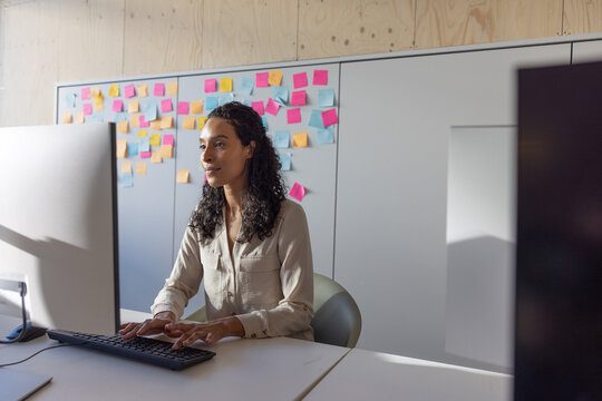 Businesswoman in an office looking at a computer screen using artificial intelligence