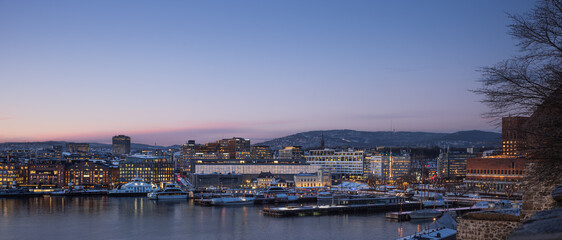 Oslo harbour in winter at twilight, with Aker Brygge, the National Museun and City Hall
