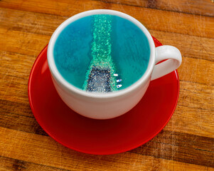 blue or turquoise summer sea with waves and boats in a cup of coffee or tea. Take a travel lake a coffee. Tourism concept foe a season trip