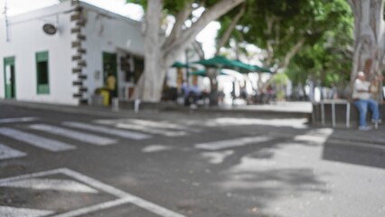 Defocused street view in lanzarote with blurred trees and outdoor cafÃ©, showcasing spanish...