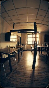 Wide angle from doorway, empty break room with abandoned coffee cups and chair askew, soft vintage filter with morning glow, suggesting aftermath of office gathering.
