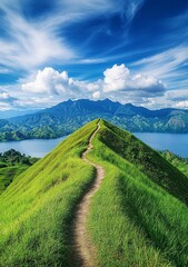 Obraz premium beautiful view of grassy mountain with blue sky in the background, there is an abandoned trail on top of it and some people walking around. 