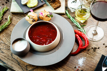 Beetroot soup Borscht with meat and sourcream in a bowl. Delicious healthy Ukrainian traditional food closeup served for lunch on a table in modern gourmet cuisine restaurant