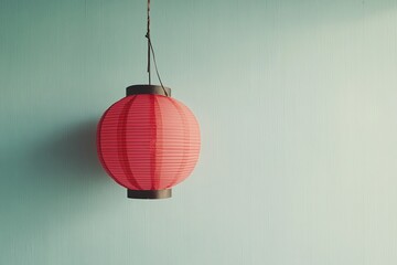 Obraz premium A minimalist shot of a single red lantern hanging against a pastel-colored wall. picture