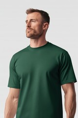 Obraz premium A plain dark green t-shirt mockup template featuring a person looking to the side against a light background. The t-shirt has a simple, clean design.