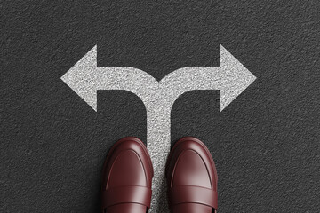 A person is standing on a white road mark of a splitting arrow on asphalt road. Illustration of the concept of decisions and different career paths