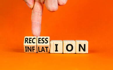 Inflation recession symbol. Businessman turns wooden cubes and changes word Recession to Inflation....