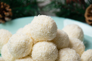Christmas, delicious homemade candies with coconut flakes and almonds on a blue plate. Concept of delicious holiday homemade food