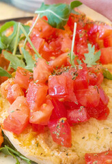 Chef preparing delicious italian fresella with tomatoes, arugula and oregano
