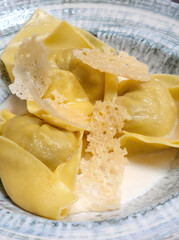 Delicious spinach and ricotta tortelloni garnished with crispy parmesan flakes in a creamy sauce