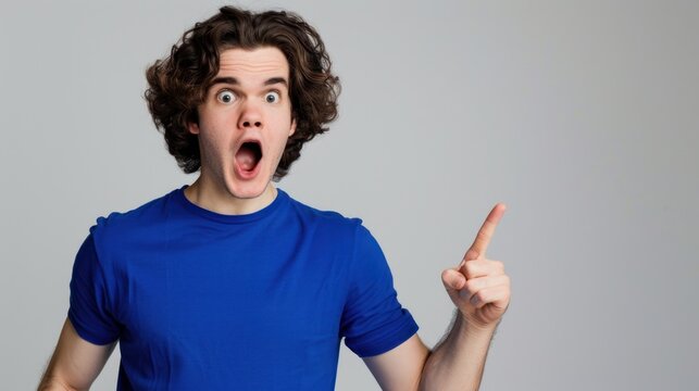 Shocked Man With Curly Hair On Neutral Gray Setting.