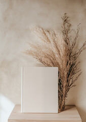 Photo of a minimalist blank journal on an elegant white table with sun rays and shadows. Top View of personal planner  Mockup paper notebook design.