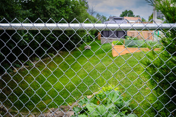 Suburban backyard decks and garden behind a chain-link fence