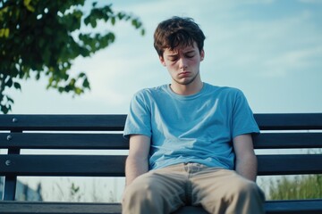 Fototapeta premium A young man sits quietly on a bench with his eyes closed, focused on meditation