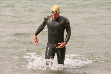 Triathlet beim Schwimmausstieg im Wettkampf, mit Neopren
