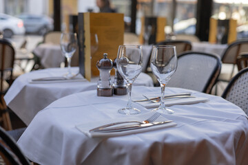 Elegant table setting for fine dining with wine glasses and cutlery in bright restaurant atmosphere