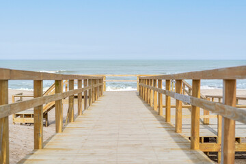Obraz premium Scenic wooden walkway inviting visitors to a bright beach
