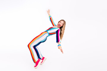 Joyful young woman in a vibrant striped outfit dancing energetically against a plain white background, embodying retro disco style