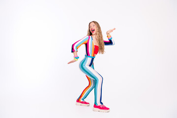 Young woman in vibrant, striped outfit dancing joyfully against a white background, capturing the essence of retro disco vibes