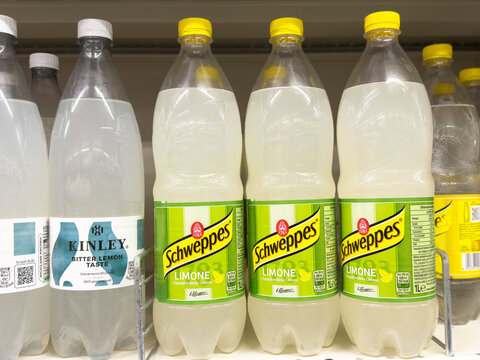 Lemonade bottles on supermarket shelf featuring kinley and schweppes brands