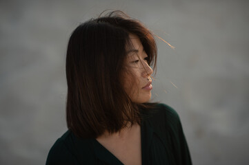 A close-up portrait of an Asian girl with freckles, plump lips, and a beauty mark above her upper...