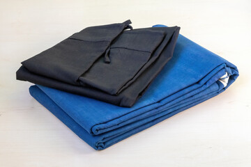 A folded blue cotton saree and black petticoat rest gracefully against a light wooden backdrop.