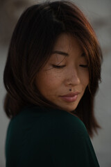 Fototapeta premium A close-up portrait of an Asian girl with freckles, plump lips, and a beauty mark above her upper lip. Her soft expression highlights her natural beauty and unique features.