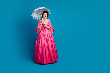 Elegant young woman in a vibrant pink corset dress on blue background, embodying classic...