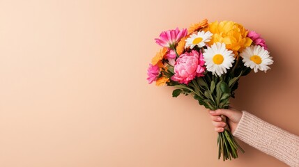 Fototapeta premium Blooming Bouquet: A delicate hand holds a vibrant bouquet of mixed flowers, their colors bursting with life against a warm backdrop, perfect for celebrating joy and love.