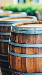 A close-up view of wooden wine barrels lined up in a rustic setting, showcasing their detailed texture and earthy colors.