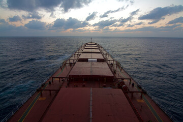 Obraz premium A merchant ship underway at sea during Sun rise