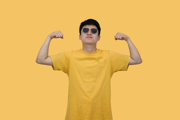 Confident young asian Man Posing in Stylish Sunglasses Against Yellow Background