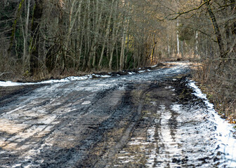 a muddy, wet road, mud texture, snow remnants, winter road