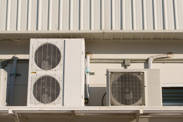Air compressor or air condenser unit located on support outside building to heat released...