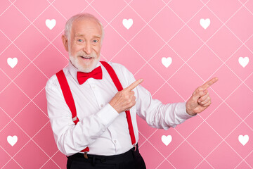 Portrait of attractive cheerful gray-haired guy showing copy blank space ad idea isolated over pink...